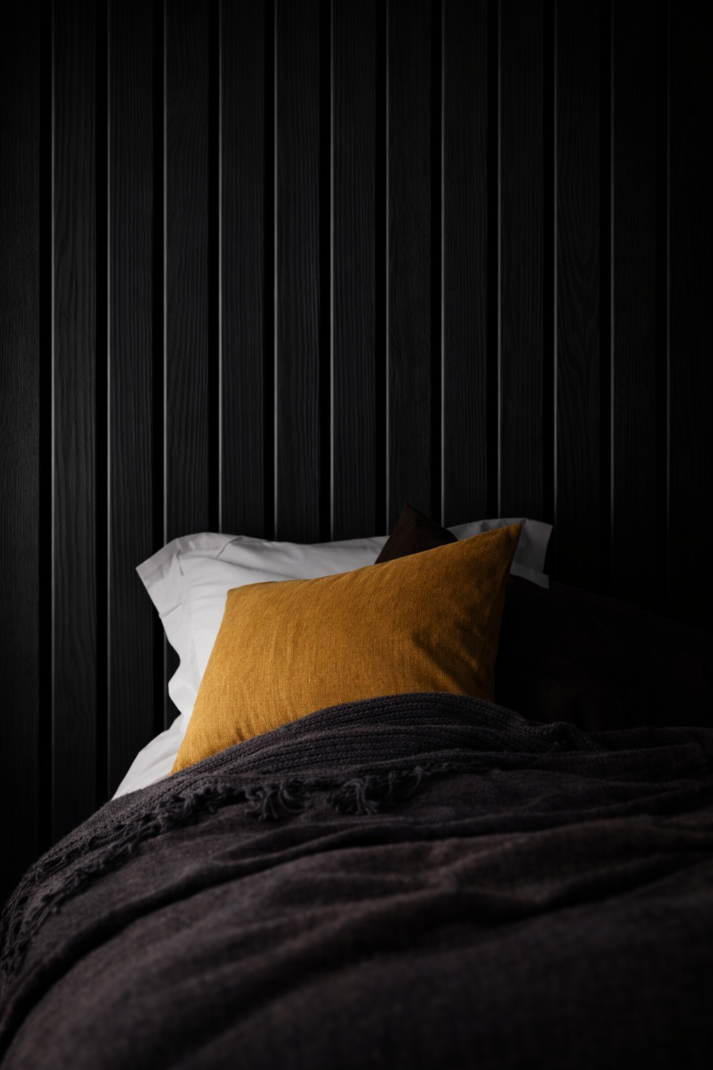Black acoustic slat panels in a bedroom 
